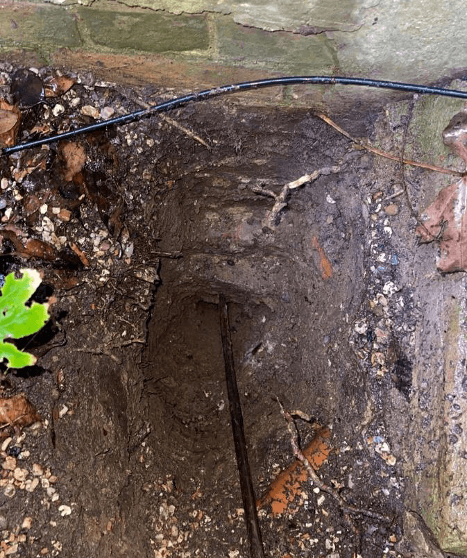 Hand-auger hole formed below the base of the trial pit