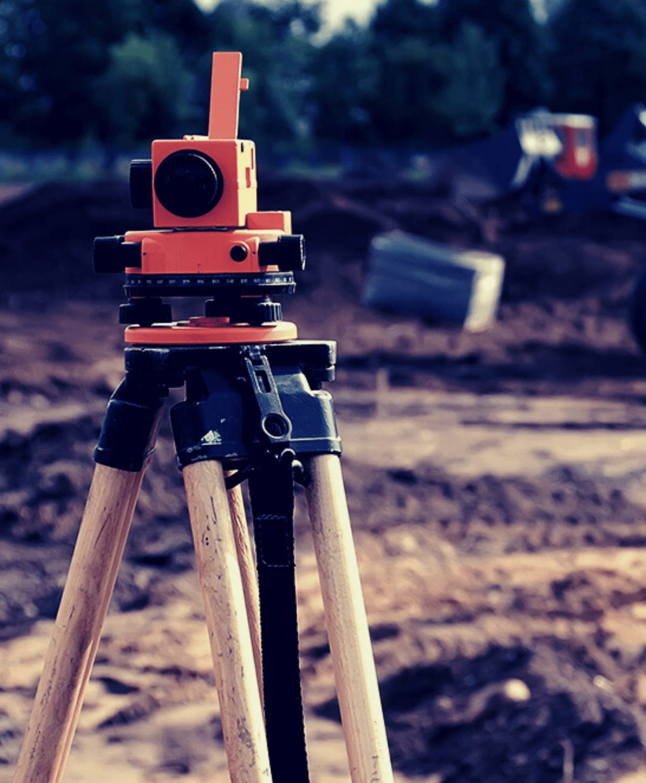 Surveyor's level on a tripod over a development site being set out